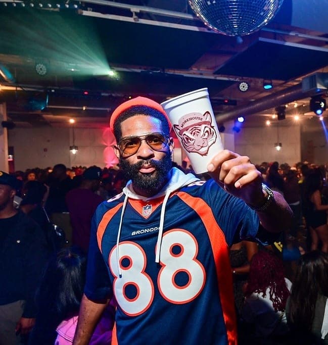 Guest in sunglasses holding a Morehouse cup at a packed SpelHouse party